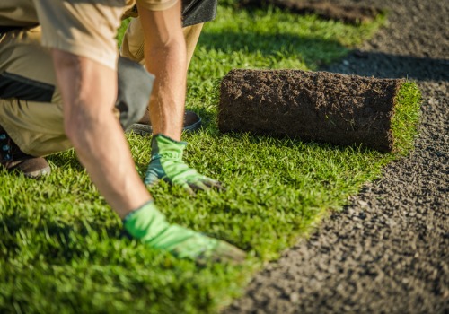 A contractor laying down sod and grass while Landscaping in Pekin IL