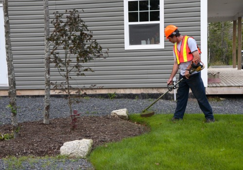 Landscapers in East Peoria IL put down mulch and trim their landscaping