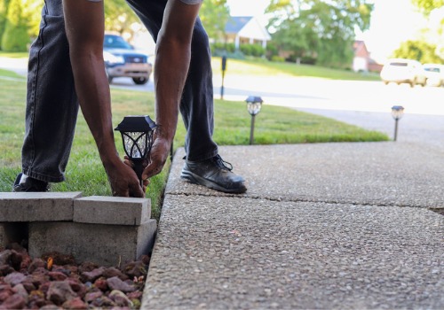 A employee of Mobeck installs outdoor lighting, which is an option business owners can choose for Commercial Landscaping in Peoria IL