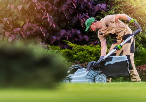 A team member of Mobeck Lawn and Landscape works on a mower, which is one part of Spring Lawn Care in Peoria IL.